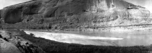 Glen Canyon near mouth of Warm Springs Creek. The nearly vertical cliff is formed of Navajo sandstone. The Todilto (?) formation is exposed near the river level. Garfield County, Utah. October 3, 1921. Courtesy USGS