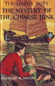 Cover of the Hardy Boys book The Mystery of the Chinese junk, with the brothers at the wheel of a motorboat.