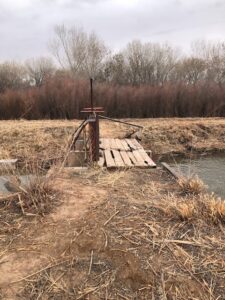Irrigation ditch crossing with trees in the background.