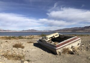 Wrecked speedboat emerging from Lake Mead mud.